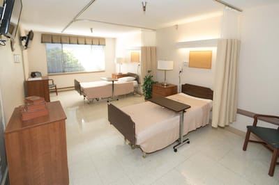 Bright, spacious resident room with two beds and light decor