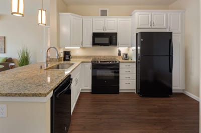 Modern kitchen featuring white cabinets and appliances