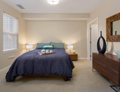 A well-furnished resident room with a bed and decor