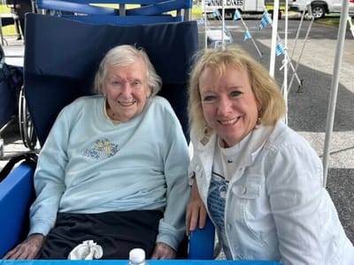 Smiling resident and staff member outdoors