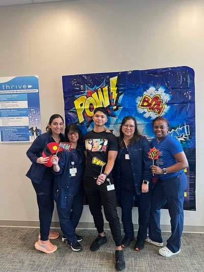 Staff members posing with fun props.