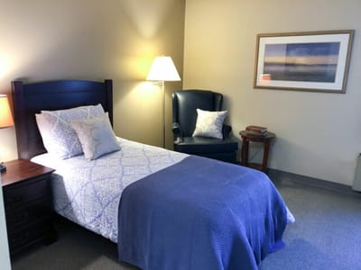 Cozy bedroom with a bed and armchair.