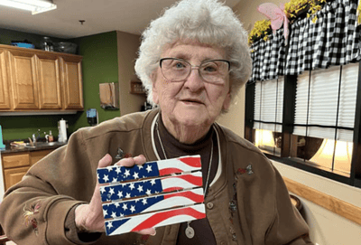 Resident proudly holding an American flag art piece.