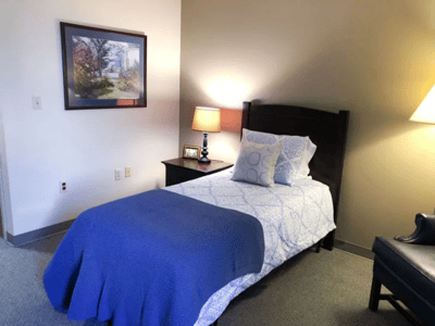 Cozy resident room with bed and lamp