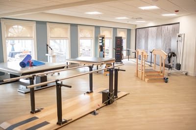 Physical therapy room with rehabilitation equipment.