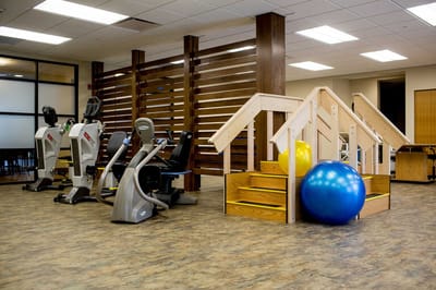 Fitness equipment and therapy space in a senior living facility.