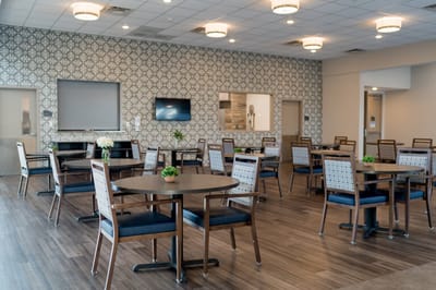Dining area with tables and chairs in a brightly lit room.