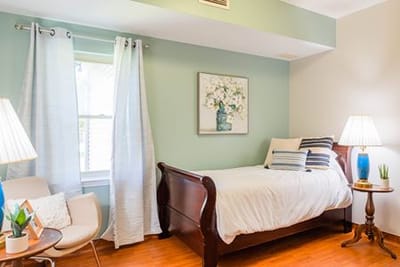 Cozy and well-lit private resident room with bed and decor