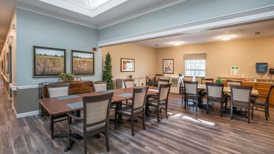 Bright common area with dining tables and artwork