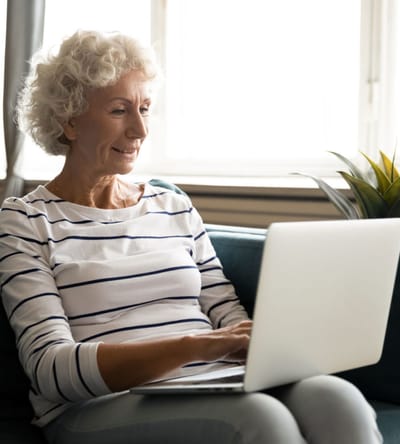 Senior woman using a laptop in her room