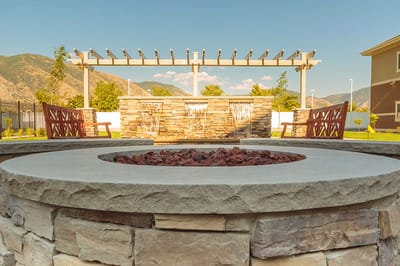 Outdoor fire pit area with benches and landscaping