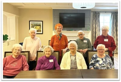Group of residents smiling in a common area.