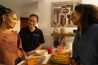 Three people enjoying cooking together in a kitchen
