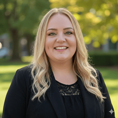Smiling staff member outdoors in professional attire.
