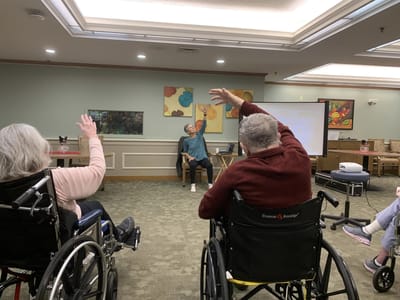 Residents in wheelchairs engaging in a group activity.