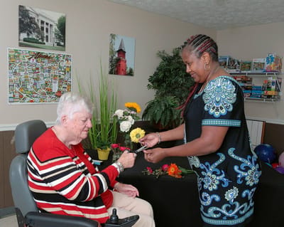 Staff helping resident with floral arrangement