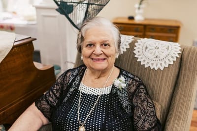 A smiling resident in a cozy chair
