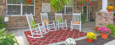 Outdoor seating area with rocking chairs and potted plants