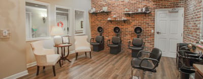 Interior view of a salon area with chairs and a brick wall