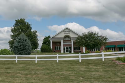 Exterior view of Colonial Manor with cloudy sky