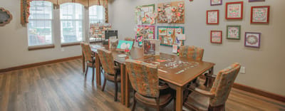 Common area with tables and colorful art displays