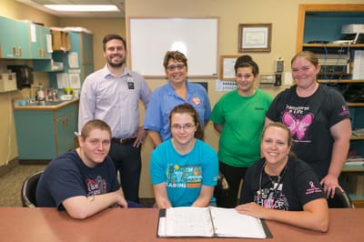 Staff members posing together in the facility common area