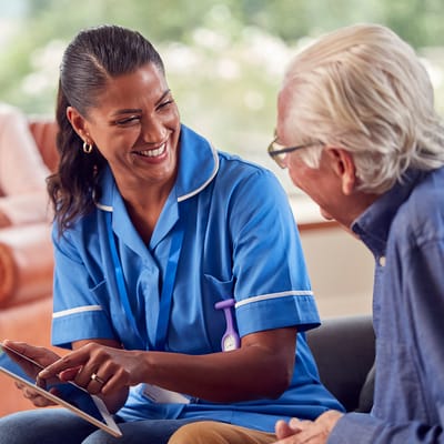 Staff member interacting with an elderly resident in a cozy setting