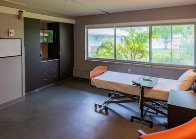 A bright, spacious resident room with a bed and window