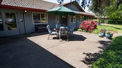 Outdoor seating area with flowers and a patio umbrella