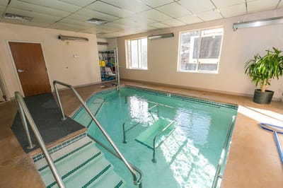An indoor therapeutic pool area with stairs