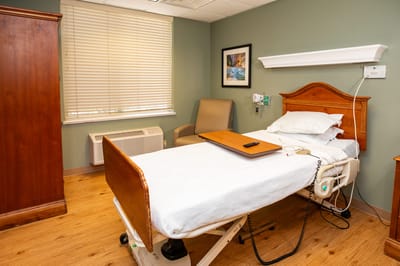 A well-equipped private resident room with a bed and armchair