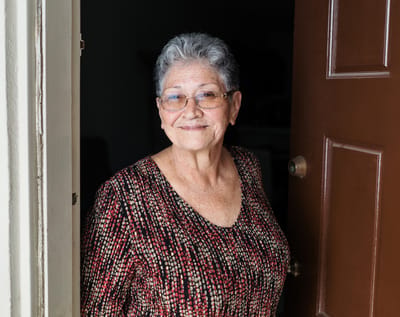 Senior woman smiling at the door