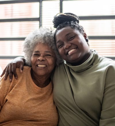 Smiling senior resident and staff member together