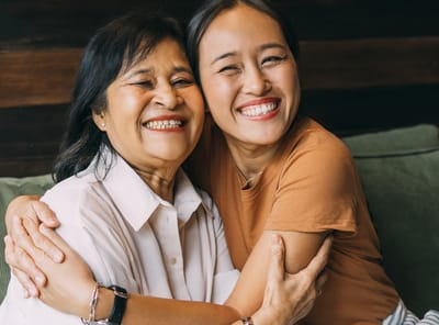 Two women smiling and embracing each other