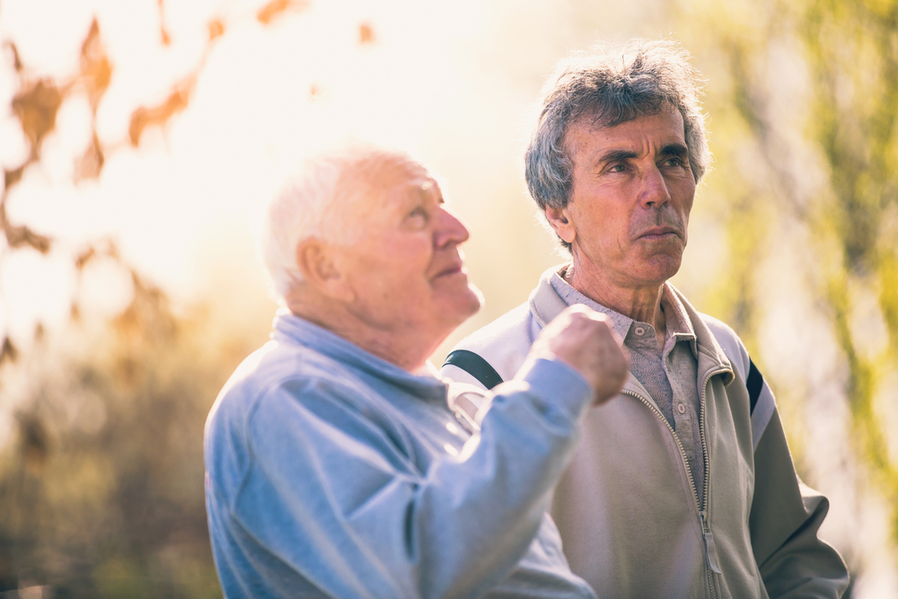 Two men talking outdoors on a sunny day
