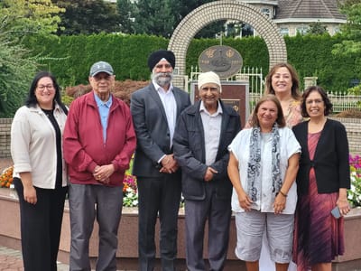 Residents and staff posing together in a garden area