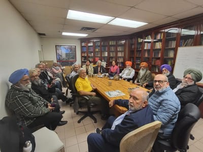 Residents and staff gathered in a common area meeting