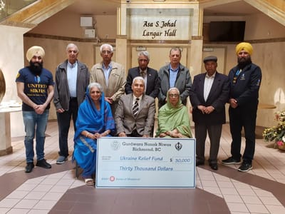Group photo with a fundraising check presentation in a lobby area
