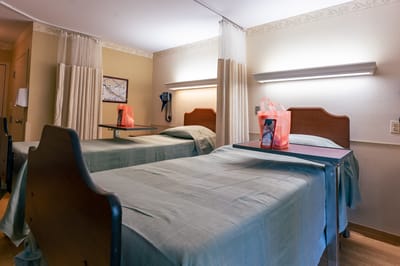 A shared resident room with two beds and gift bags