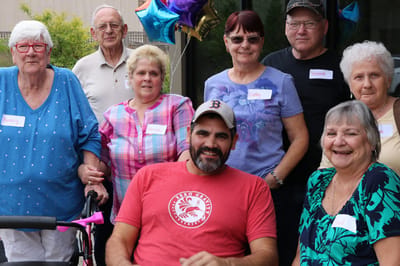 Residents and staff celebrating together with balloons