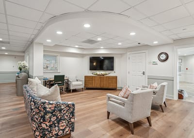 Common area with seating and TV in a senior living facility