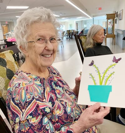 Resident holding a craft project in the common area.