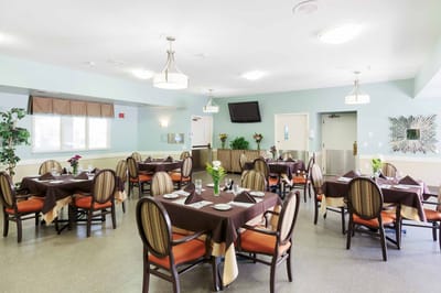 Dining room set for a meal with flowers on tables