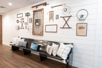 Decorative wall with various framed pieces and cushions