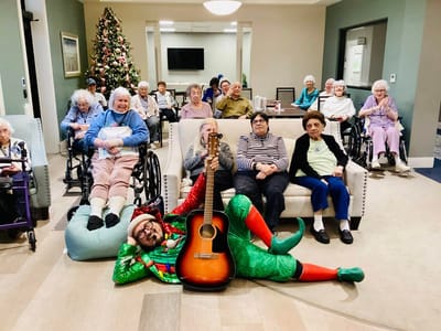 Residents enjoying music in a common area decorated for the holidays
