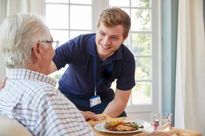 Staff serving a meal to a resident