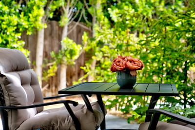 A patio table with a bouquet of flowers in an outdoor space