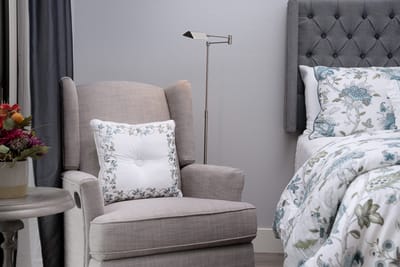 Cozy bedroom corner with armchair and flowers