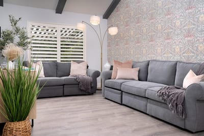 Cozy common area with gray couches and decorative wallpaper