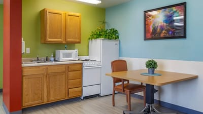 Bright kitchenette area with plants and artwork